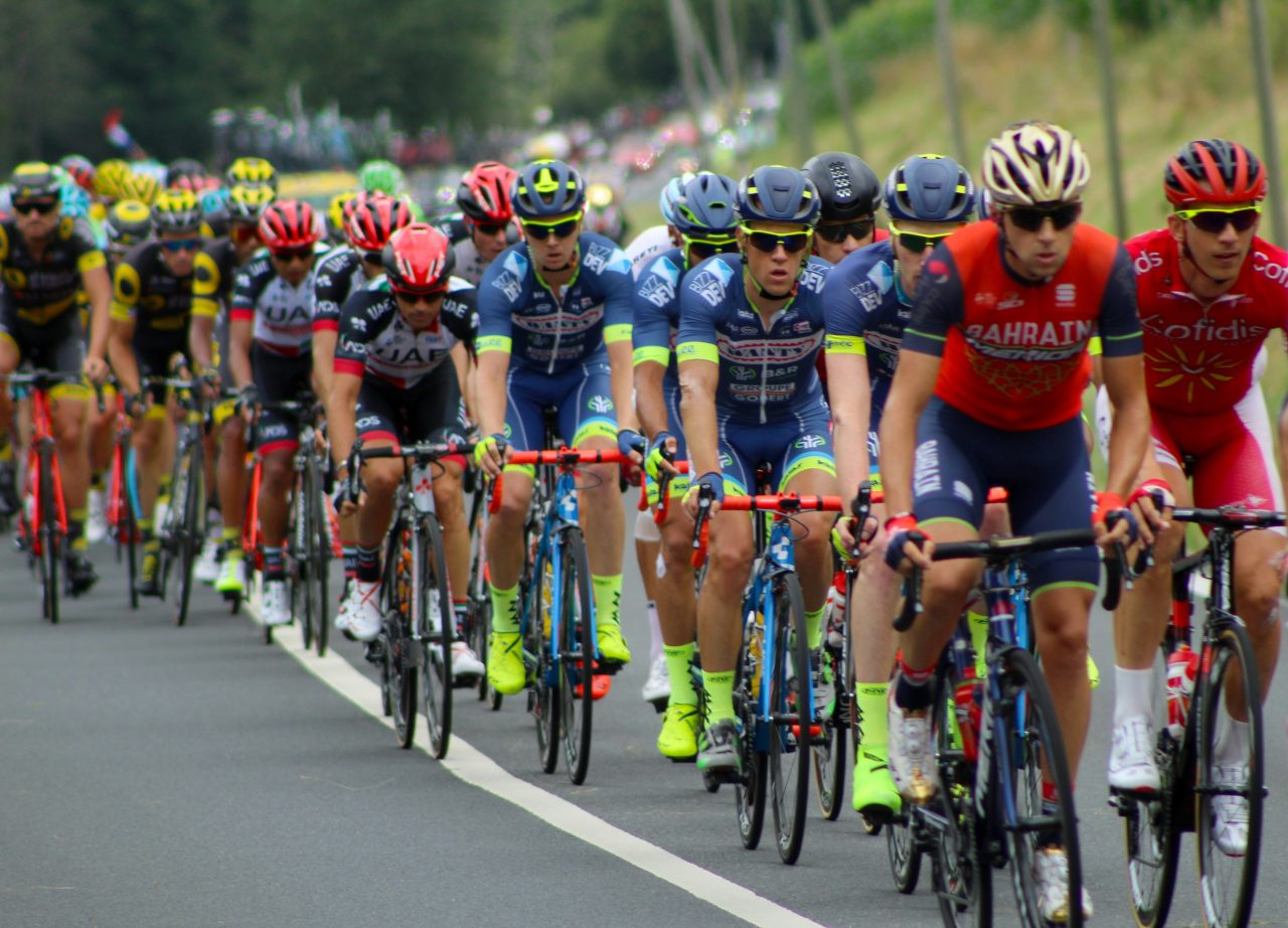 Professional cyclists riding up a hill