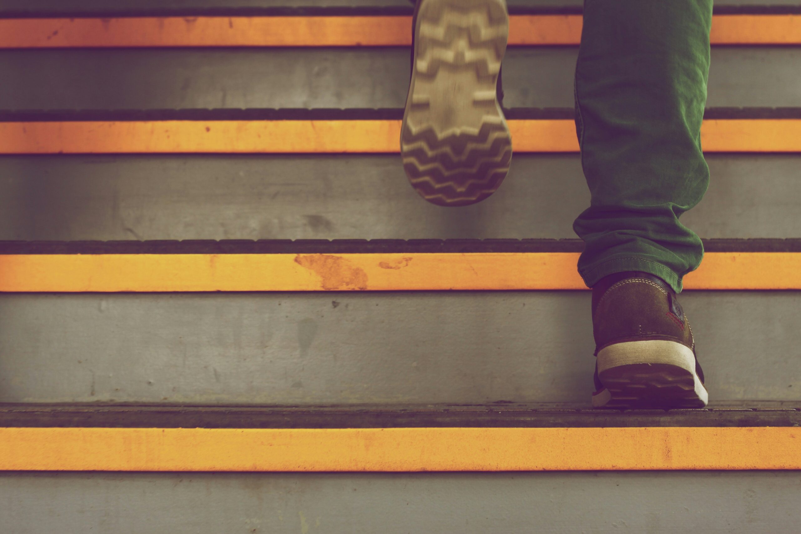 Photos on man's legs and feet walking up stairs